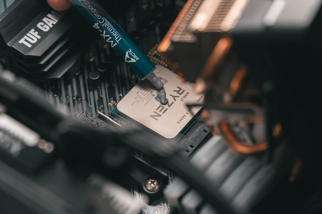 About a-close-up-of-a-person-holding-a-pen-near-a-computer-motherboard-gmfb1p9t3i8