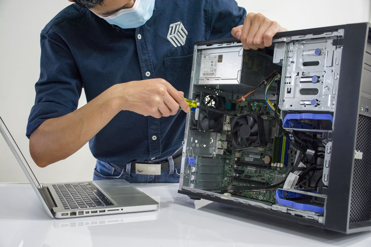 About A technician repairs a desktop computer in an indoor setting, illustrating tech maintenance.